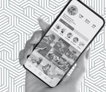 holding phone with Instagram profile to highlight power of consistently posting on social media